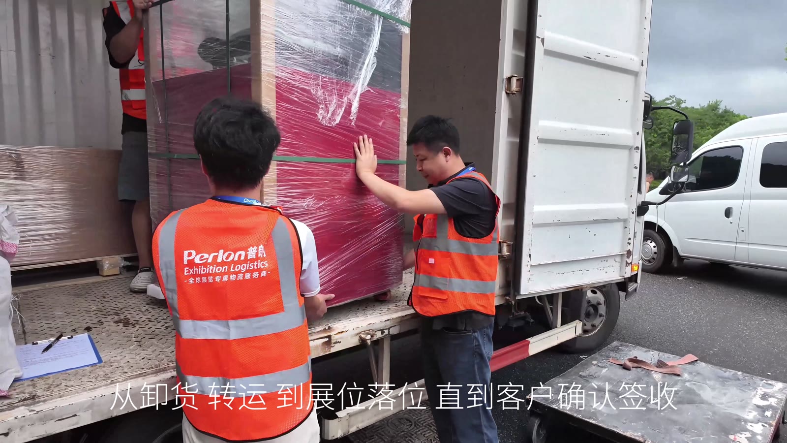 普朗物流宣传片画面:身着普朗工服的工作人员在车辆旁协同装卸包装展品